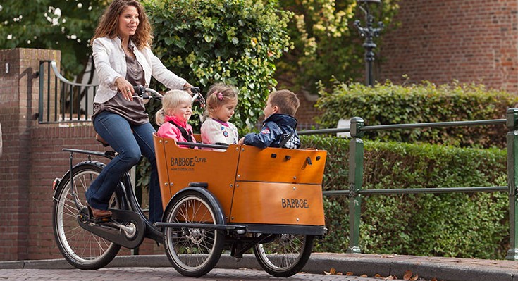 Madre pasea a tres niños en su bici de carga
